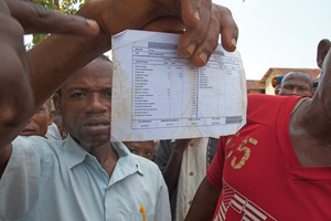 A citizen of Bolesa, in the DR Congo, showing the salary paid by Feronia (about US$ 30 for 26 days of work). Photo: Argia