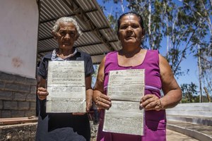 Dos mujeres del pueblo de Santa Fe en el municipio de Santa Filomena muestran sus títulos de tierras, en septiembre de 2017. La gente de Santa Fe ha vivido en esta parte del Estado de Piauí en Brasil por más de 200 años, pero ahora son víctimas de una ola de acaparamientos de tierra en el área perpetrados por empresarios brasileños y financiados por empresas extranjeras como el fondo de pensión TIAA que tiene su sede en Estados Unidos. (Foto: Rosilene Miliotti / FASE)