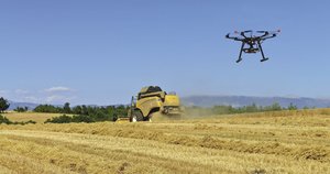 Aerial drone and combine harvester in a version of the new pastoral in a French wheat field. Photo: incamerastock/Alamy